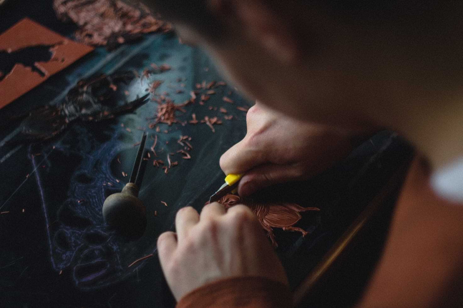 A man cutting a block of linoleum